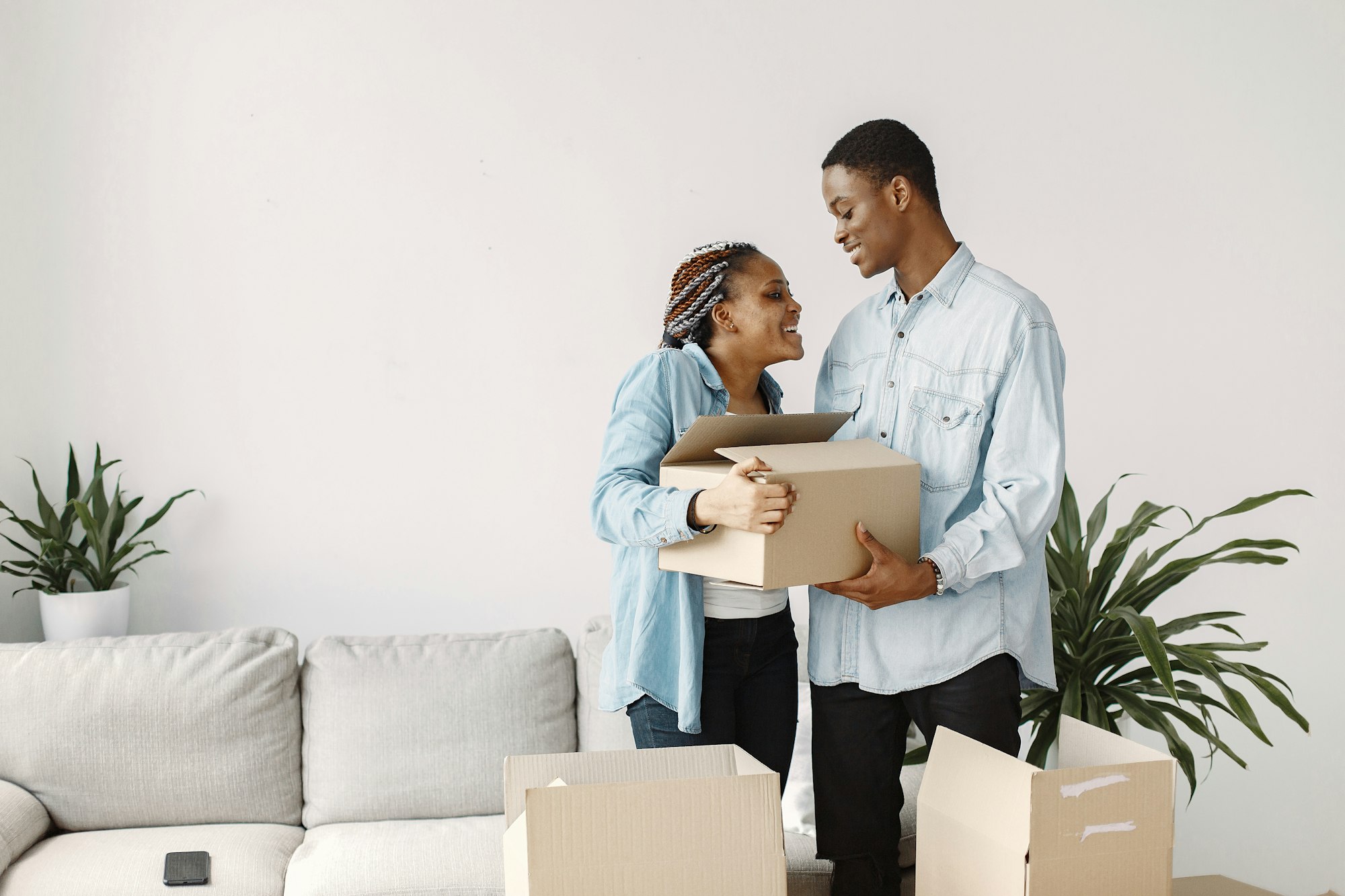 Couple with boxes moving into new home smiling